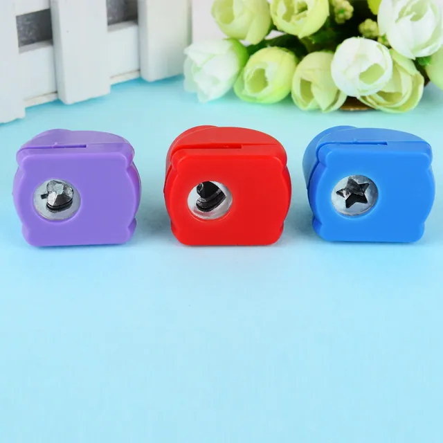 Three cube sharpeners in purple, red and blue on a blue ground